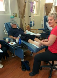 Andrea providing foot massage to a patient receiving chemotherapy